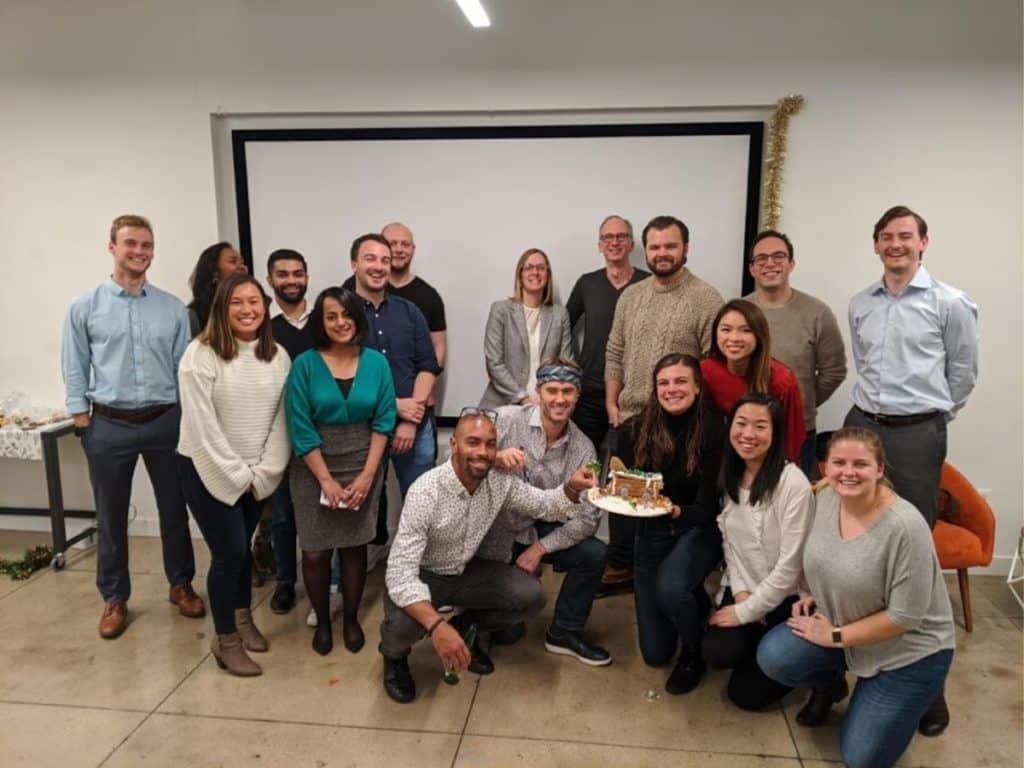 group standing in front of screen with gingerbread house