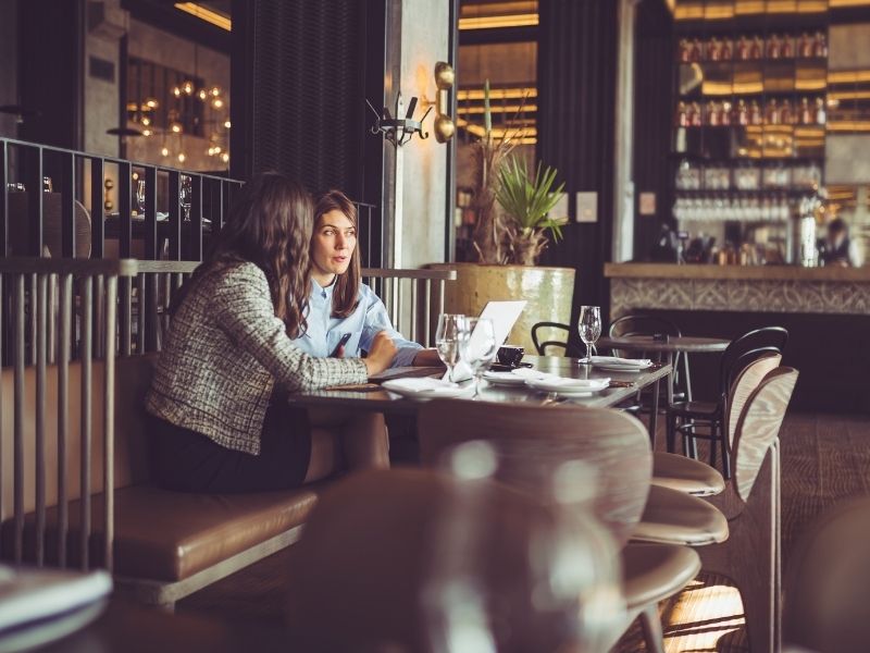 Two women having lunch and working