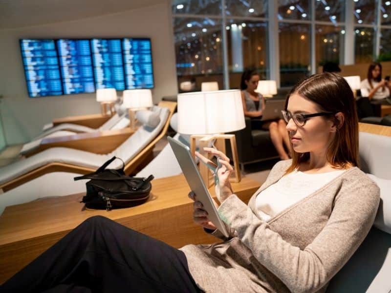 A woman lounging and looking at an iPad